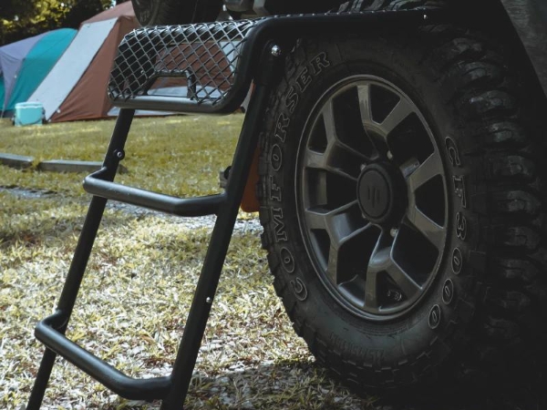 黑色的車梯踏板使用鋼板網(wǎng)，架在車輪上。