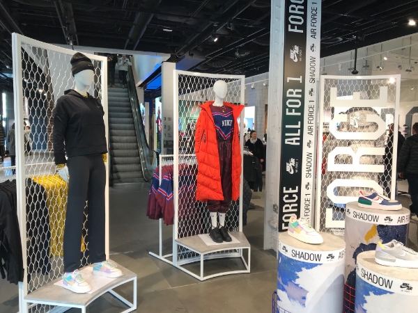 模特站在白色鋼板網(wǎng)的展示架前面。